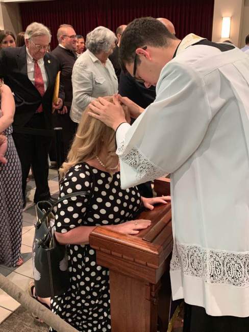 Father Luke Wilgenbusch praying over Susan